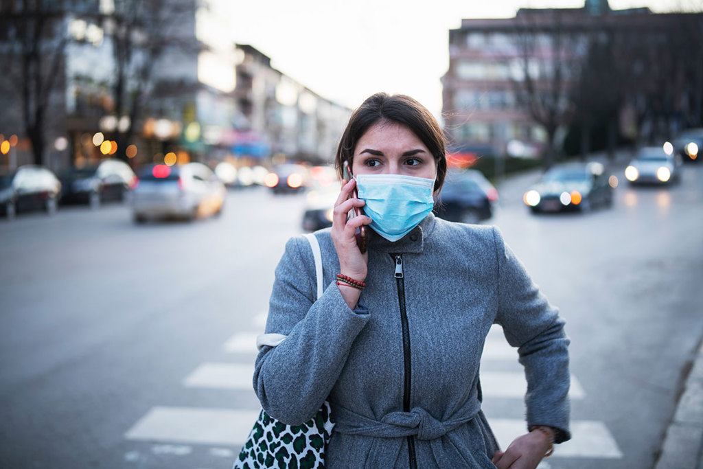 woman wearing protective mask walking down street