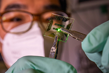 Photo of scientist with OLED device